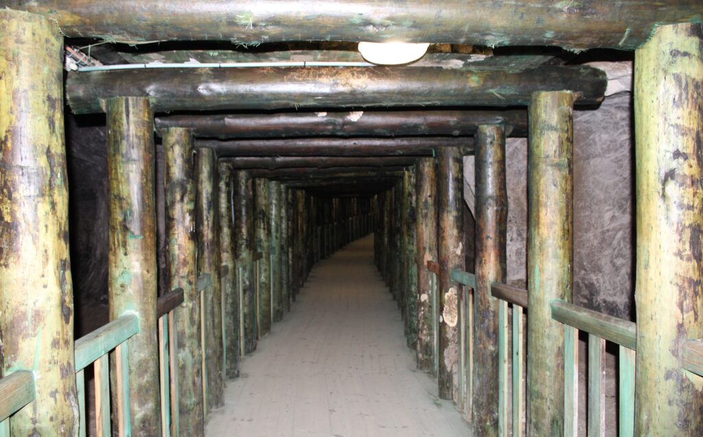 Drewniana, zabezpieczona kładka biegnąca przez wnętrze Grot Nagórzyckich. Konstrukcja wsparta na drewnianych belkach prowadzi turystów przez podziemne korytarze dawnej kopalni piasku.